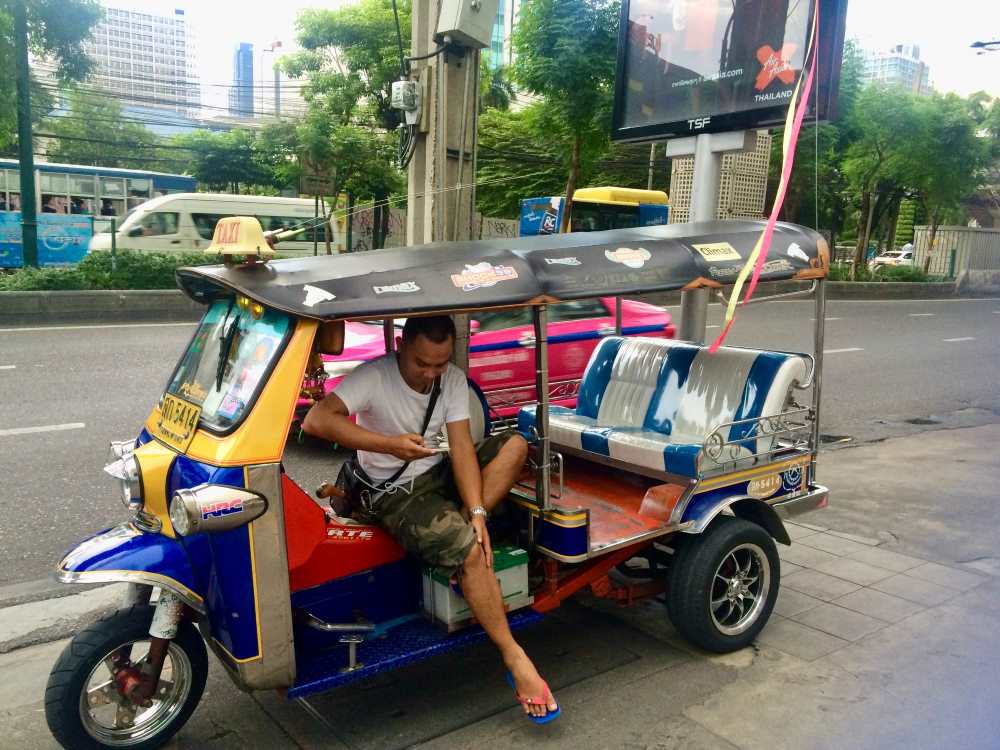 barbat care sta intr-o plimbare cu tuktuk langa drum
